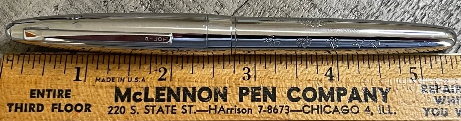 Chrome-plated Pilot Namiki fountain pen with silver body, black nib, and engraved oval logo on side.